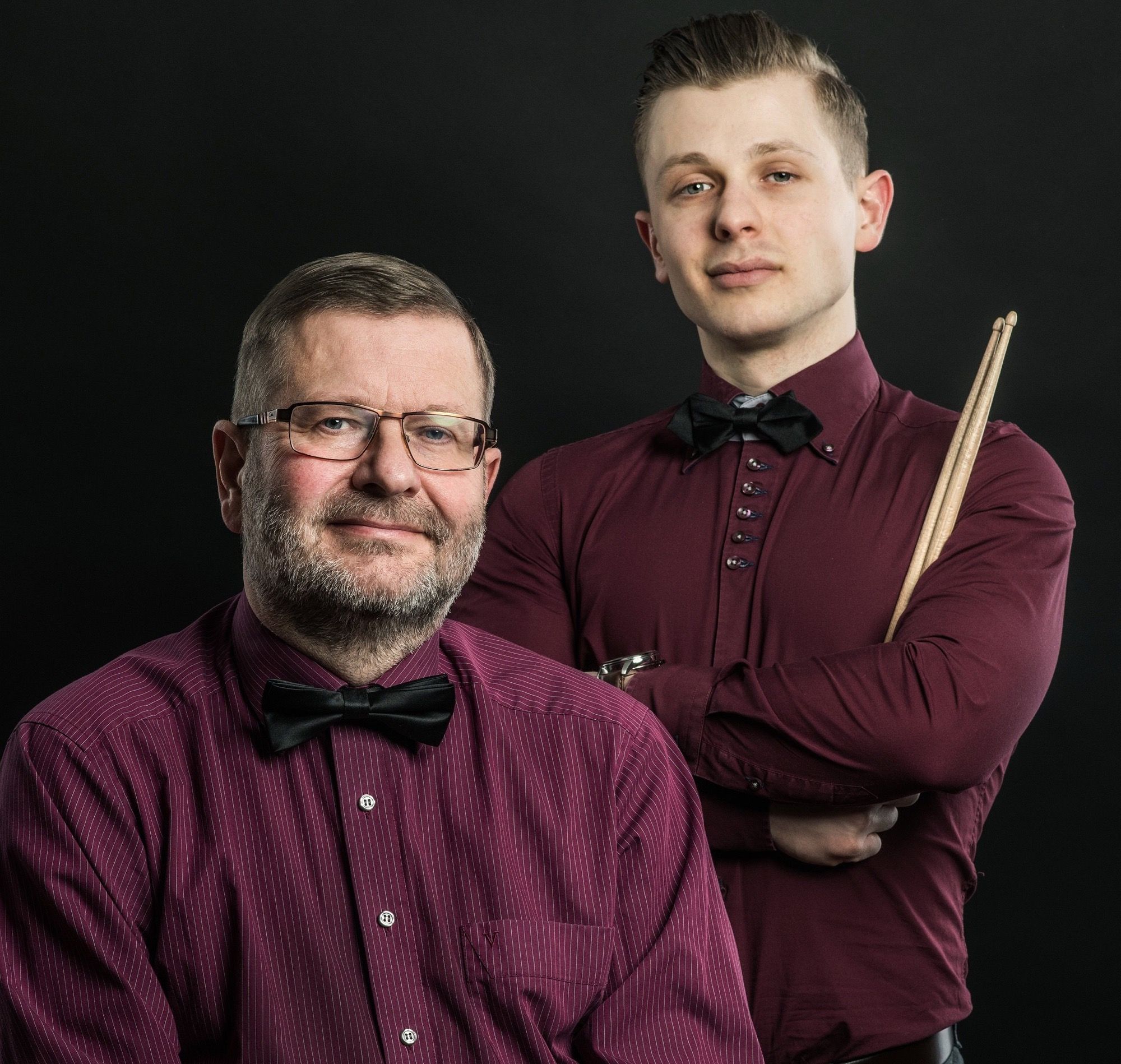 Porträt von Alexander und Maximilian Blume in weinroten Hemden mit Trompete und Drumsticks