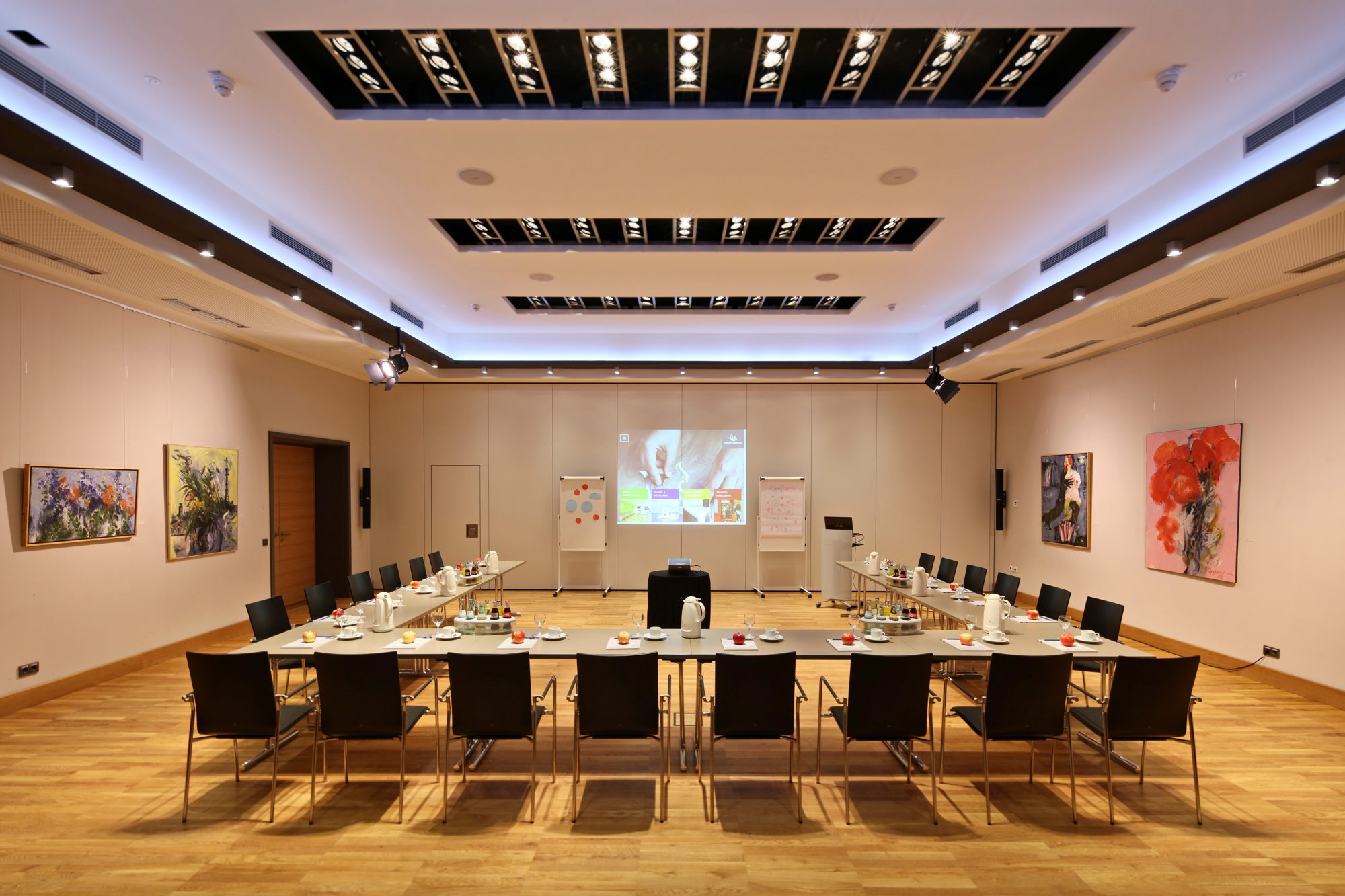 Tagungssaal im ArtHotel Kiebitzberg mit U-förmiger Tafel, Flipcharts, Beamer und Kunstwerken an den Wänden
