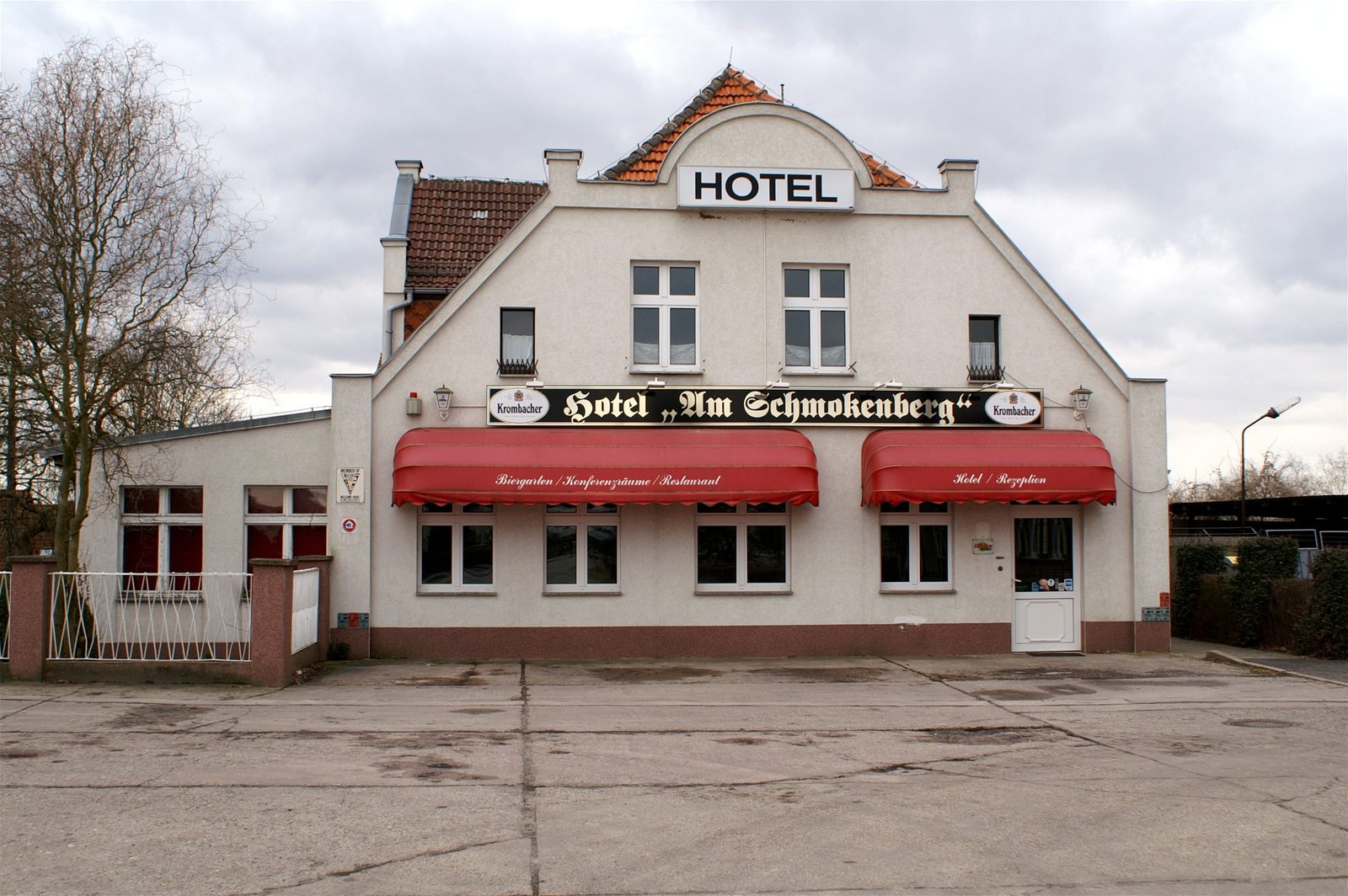 Fassade Hotel Am Schmokenberg mit HOTEL-Aufschrift und roten Markisen über Café, Restaurant und Rezeption