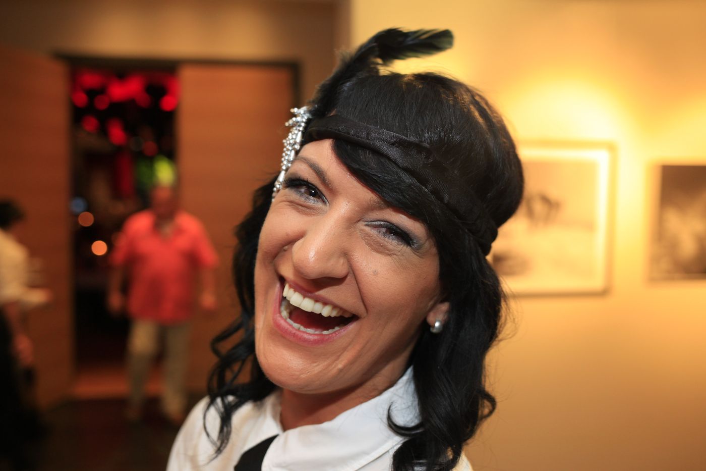Laughing woman in a Charleston costume with a feather headband at the New Year’s Eve party