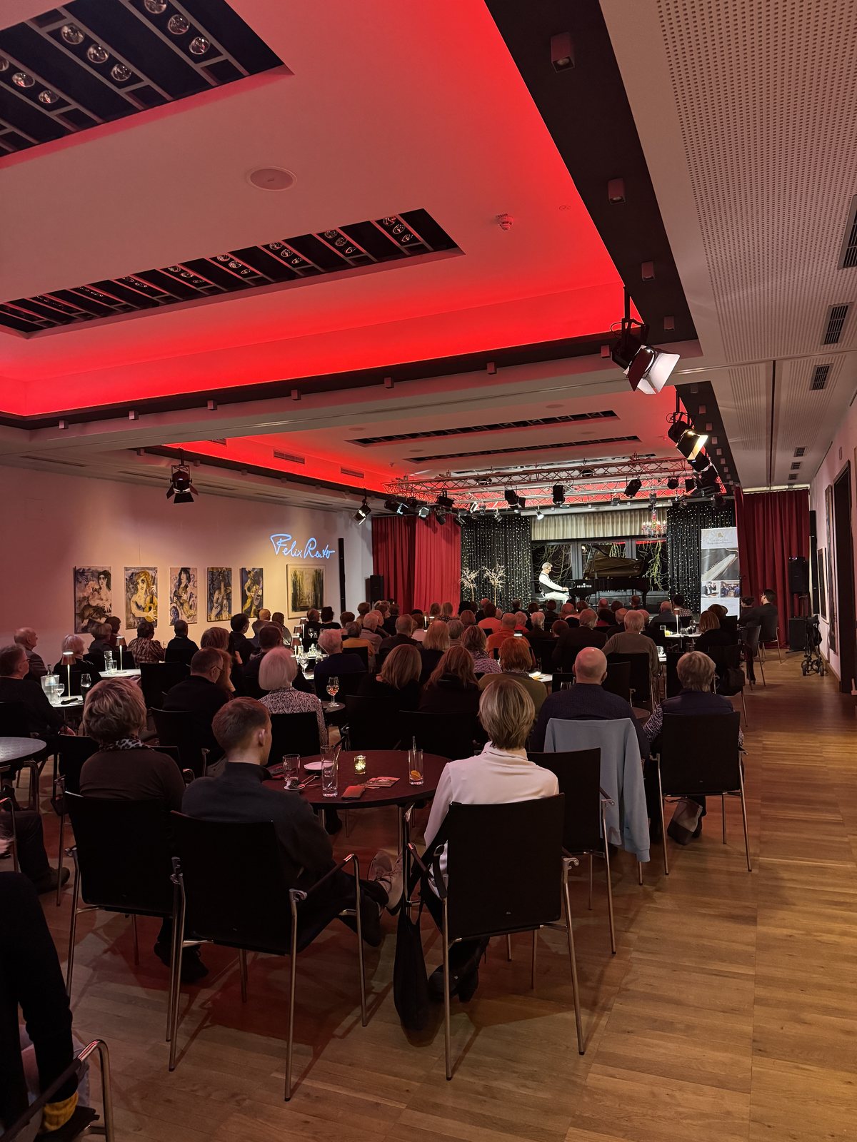 Konzertpublikum vor der Bühne im rot beleuchteten KunstQuartier des ArtHotel Kiebitzberg