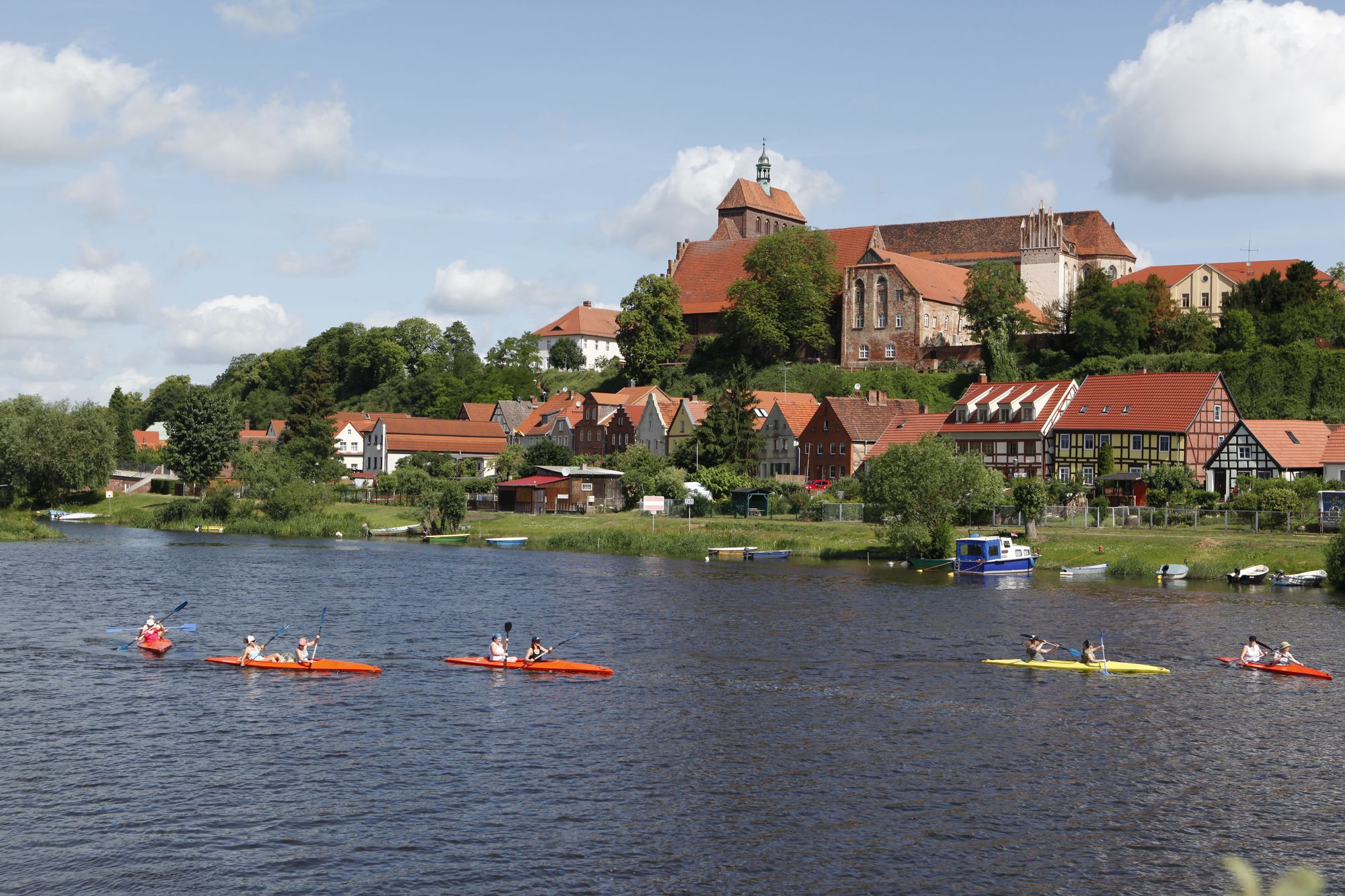Blick über die Havel auf die Altstadt von Havelberg mit Dom, Fachwerkhäusern und Kanus auf dem Wasser