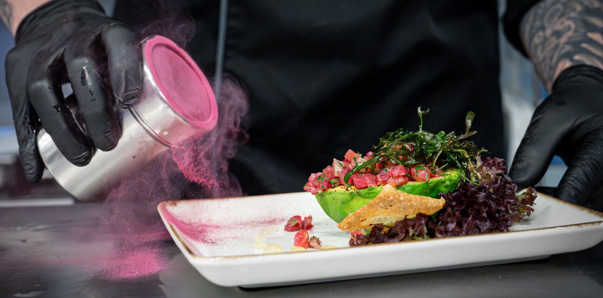 Koch richtet Thunfisch-Tatar mit Avocado an und verfeinert den Teller im Restaurant Schmokenberg