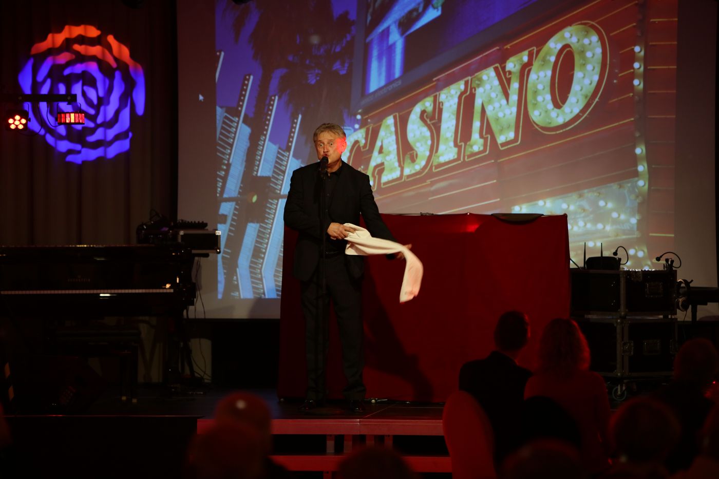Entertainer on stage before a glowing casino projection at the New Year’s Eve gala