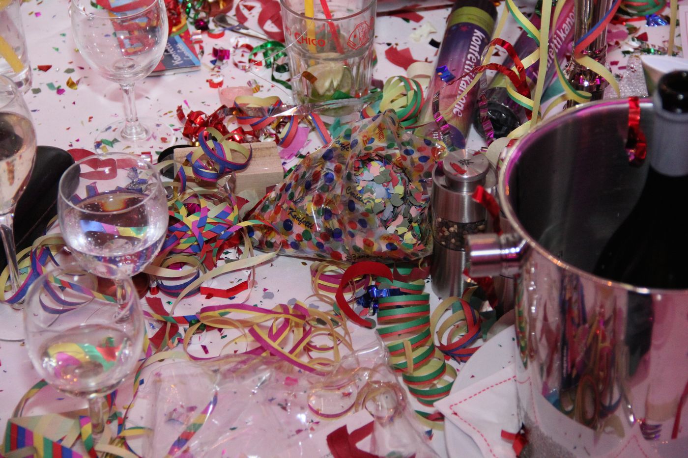 Festively laid table with confetti, streamers and a wine cooler after the turn of the year