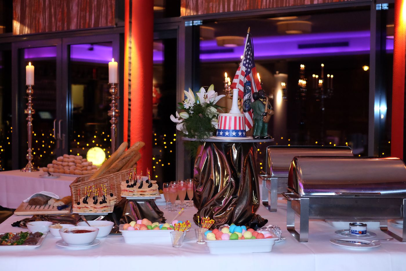 Festive New Year’s Eve buffet with finger food, sweets, chafing dishes and a Hollywood cake with a US flag at ArtHotel Kiebitzberg