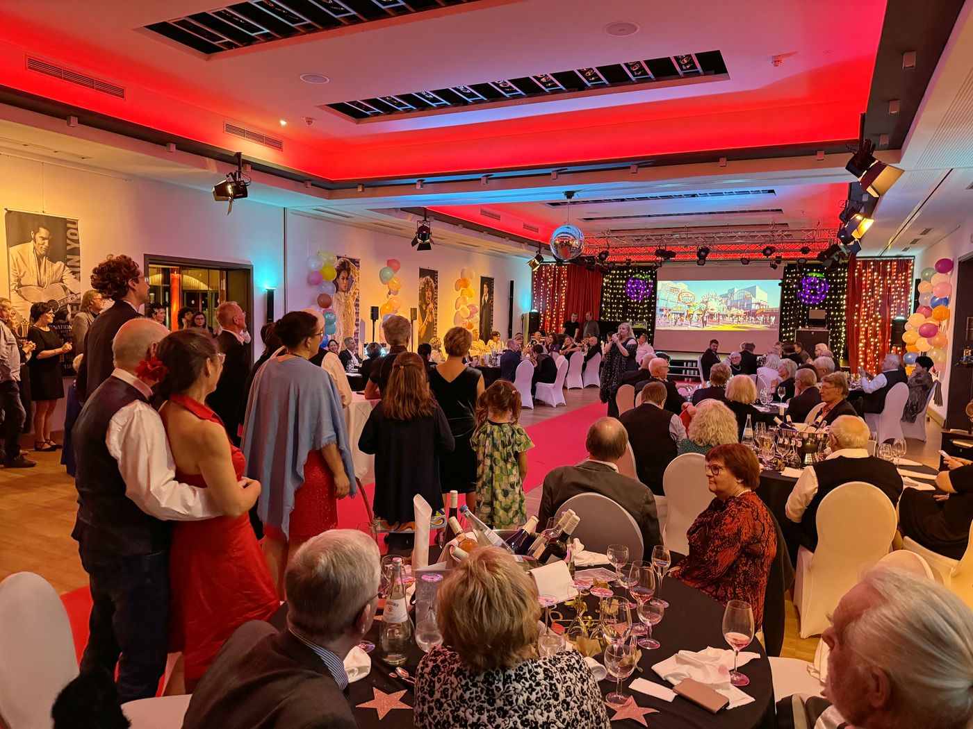Guests in evening wear celebrating in the festively lit hall of ArtHotel Kiebitzberg during the New Year’s Eve gala