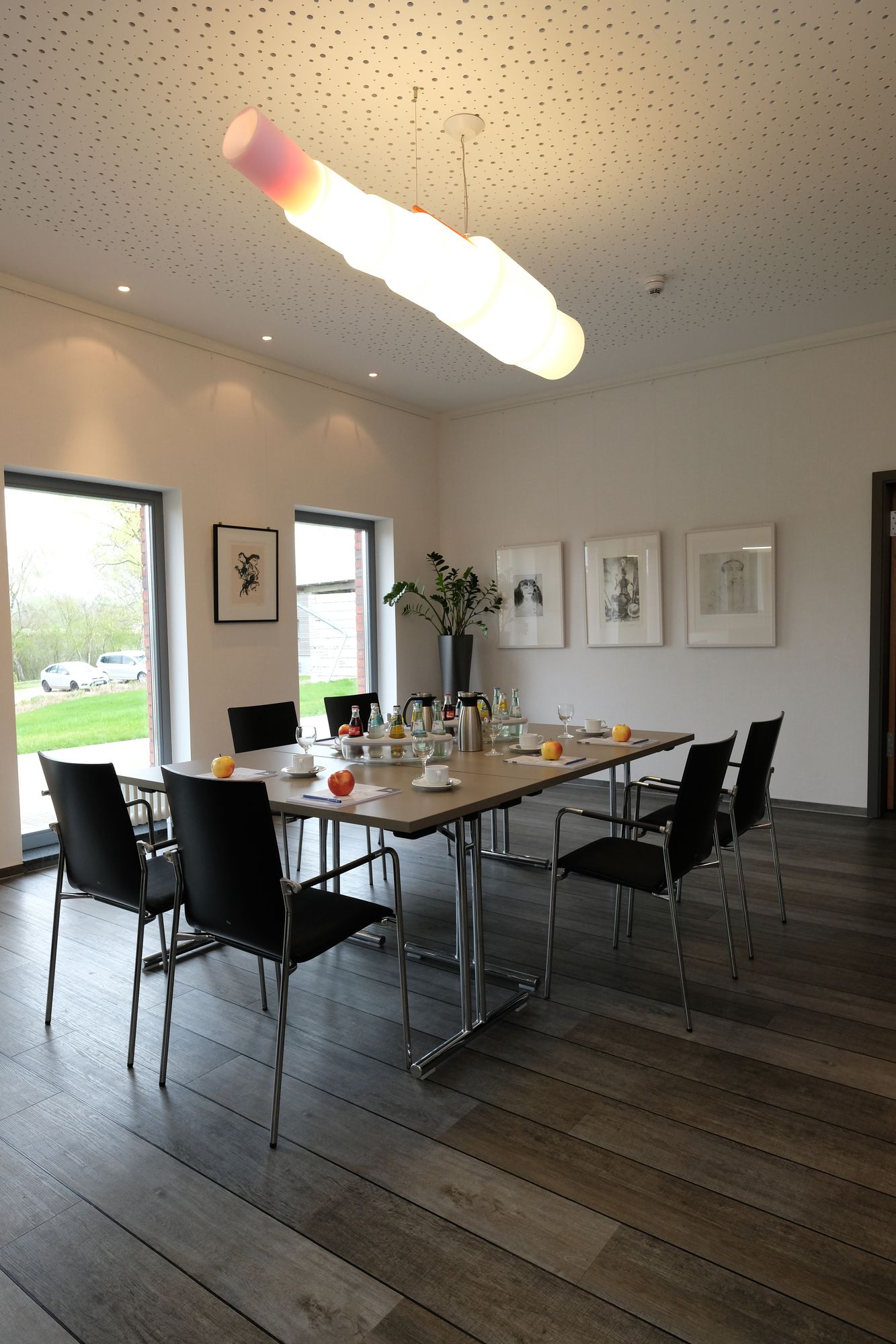 Heller Tagungsraum im ArtHotel Kiebitzberg mit Konferenztisch, schwarzen Stühlen und Kunst an den Wänden