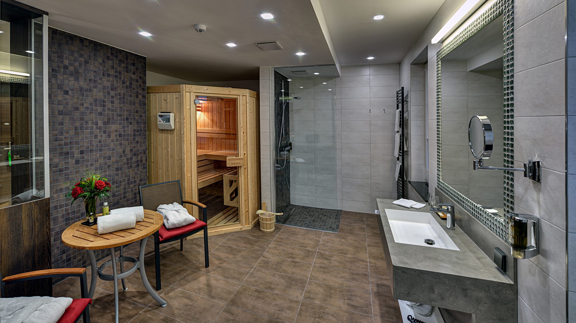Private wellness suite at ArtHotel Kiebitzberg with its own sauna, rain shower and seating corner with roses